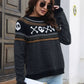 A woman wears a black long-sleeve sweater with a ghost and skull pattern.