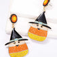 Two dangle earrings feature a witch's hat on a candy corn-shaped body with a smiling face.