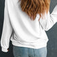 A woman from behind wears a white long-sleeve sweatshirt and blue jeans.