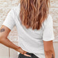 A woman from behind wears a white short sleeve t-shirt and dark jeans.