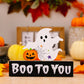 A ghost and pumpkin ornament on a black base that reads "Boo To You".