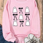 Pink long-sleeve sweatshirt with ghost and bow graphics, paired with jeans and sneakers.