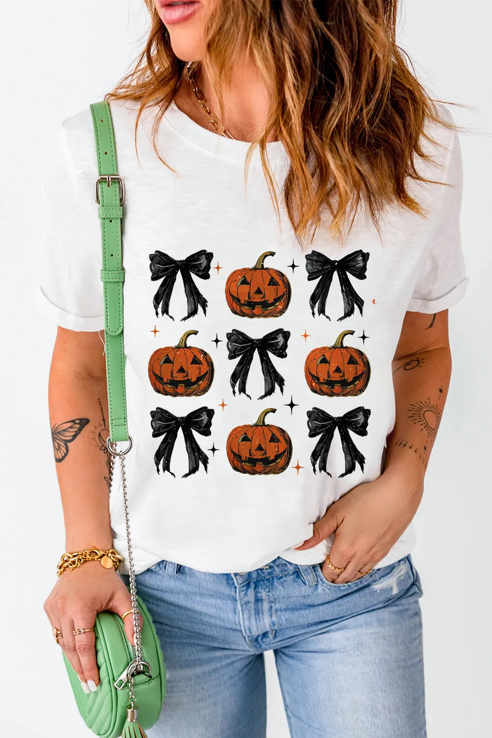 White short-sleeve t-shirt with a pumpkin and bow pattern.
