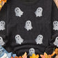 Black long-sleeve sweatshirt with glitter ghost print, styled with jeans and autumn leaves.