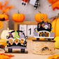 Three wooden Halloween car-shaped ornaments featuring gnomes and pumpkins.