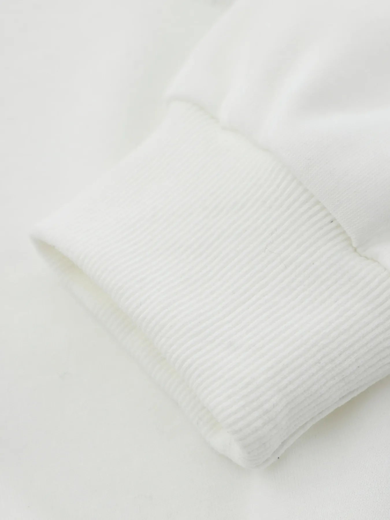 Close-up of a white ribbed cuff on a Men's Spider Graphic Oversized Hoodie.
