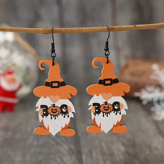 A pair of wooden dwarf pumpkin dangle earrings with orange hats and white beards.