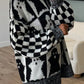 Black and white ghost-patterned dropped shoulder long sleeve sweater.