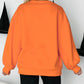 A blonde woman from behind wears an orange Halloween skeleton pumpkin sweatshirt.
