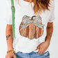 A woman wears a white short-sleeve t-shirt with a striped pumpkin and leopard print bow.