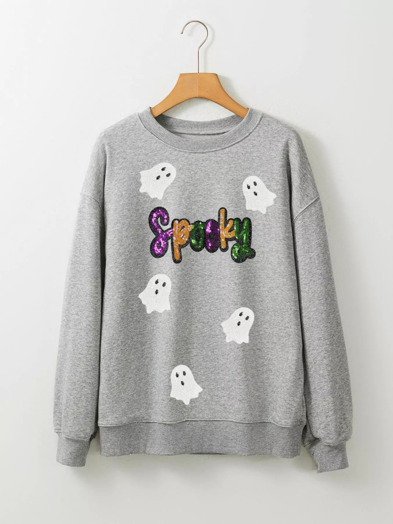 A gray sweatshirt with sequined "Spooky" text and ghost appliques.