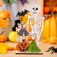Two wooden Halloween ornaments feature a skeleton, ghost, pumpkin, and broomstick.