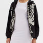 Skeleton zip-up drawstring hoodie worn over a white ribbed dress.