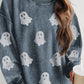 A woman wears a blue corduroy long-sleeve sweatshirt with glitter ghost appliques.