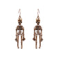 Two bronze-colored skeleton alloy earrings hang from hooks.