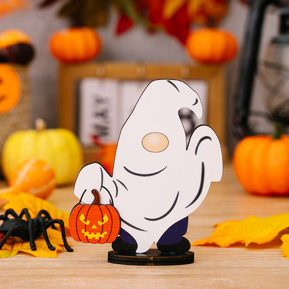 A ghost gnome ornament holding a pumpkin, surrounded by Halloween decorations.