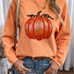 A woman wears an orange ribbed sweatshirt with a sequined pumpkin design.