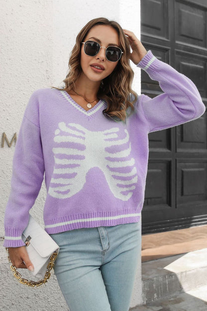 A woman wears a purple skeleton pattern V-neck long sleeve pullover sweater.
