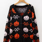 Black button-up cardigan with orange and pink Halloween pumpkin and bow patterns.