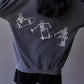 An oversized gray sweatshirt with three white skeleton graphics skateboarding on the back.