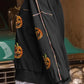 Black long-sleeve sweatshirt with sequin pumpkin designs and colorful shoulder piping.