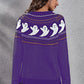 A woman models a purple long-sleeve sweater with a ghost pattern on the back.