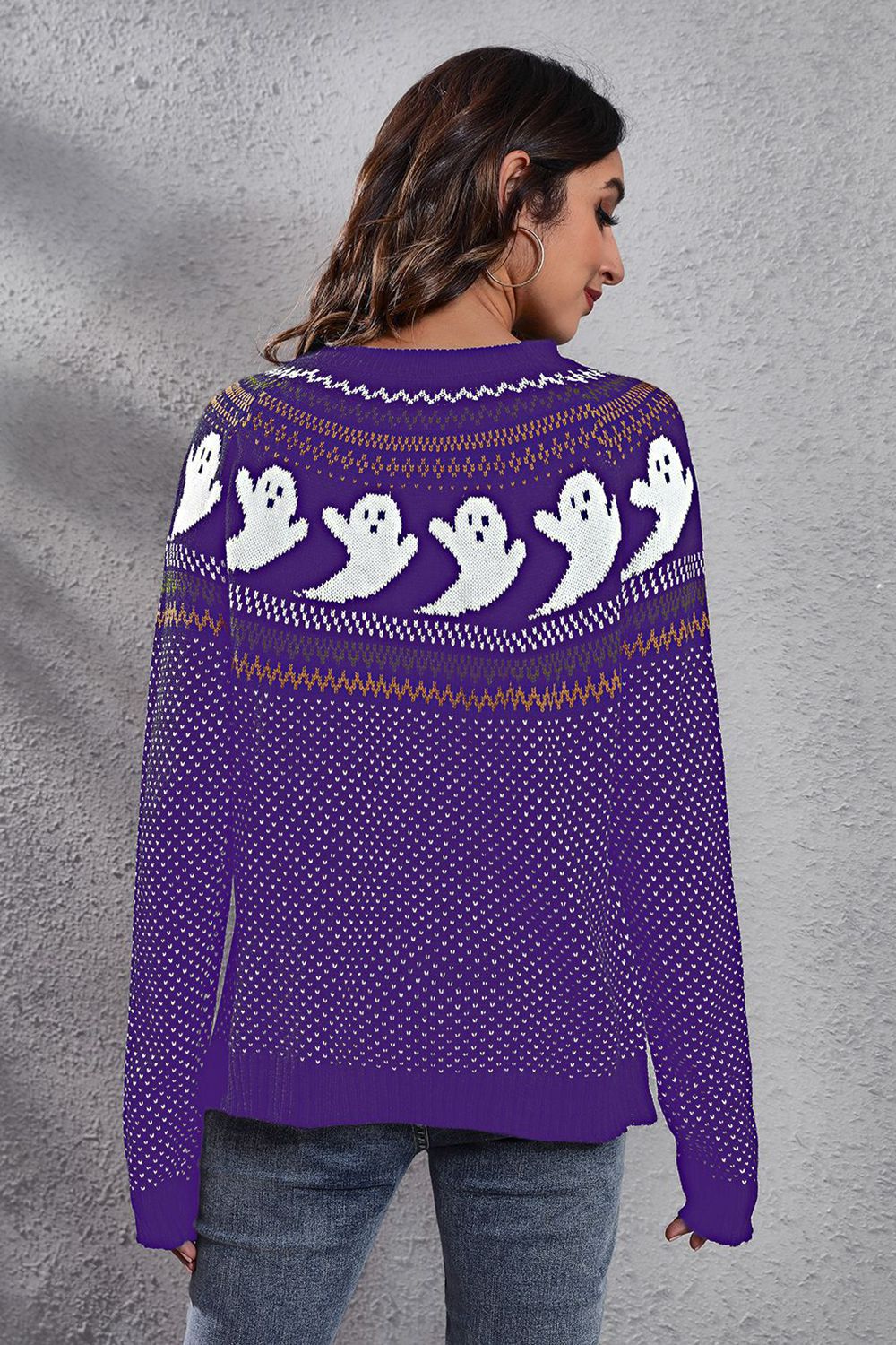 A woman models a purple long-sleeve sweater with a ghost pattern on the back.