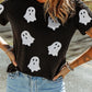 Black short-sleeve t-shirt with glitter ghost print and light wash jeans.