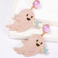 Two ghost-shaped dangle earrings with pink synthetic pearls and black and blue accents.