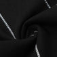 Close-up of black denim fabric with white chain-stitch embroidery.
