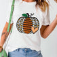 A woman wears a white short-sleeve t-shirt with a pumpkin graphic.