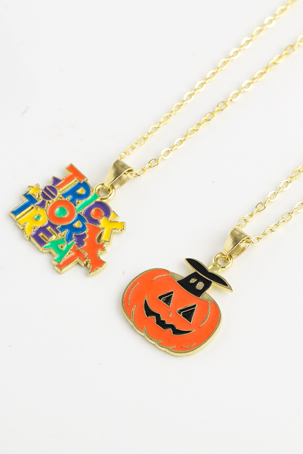 Two Halloween-themed necklaces, one with "Trick or Treat" and one with a jack-o'-lantern.