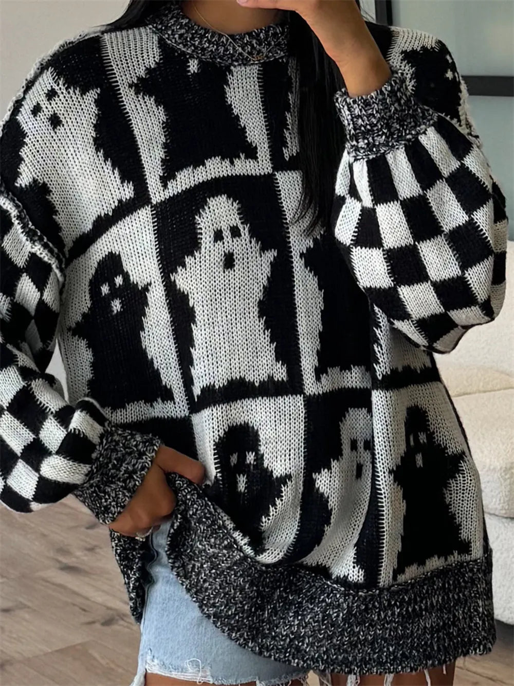 Black and white ghost pattern sweater with checkerboard sleeves.
