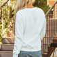 Pumpkin Graphic Long Sleeve Sweatshirt in white, worn with denim shorts.