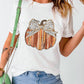 A woman wears a white short-sleeve t-shirt with a pumpkin graphic.