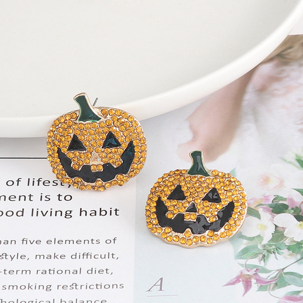 Two rhinestone-encrusted pumpkin earrings with black jack-o'-lantern faces.