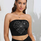 A woman models a black tube top with a rhinestone heart spider web graphic.