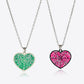 Two heart-shaped necklaces, one green and one pink, with spiderweb designs.