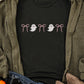 Black short sleeve t-shirt with pink bows and white ghost graphics.