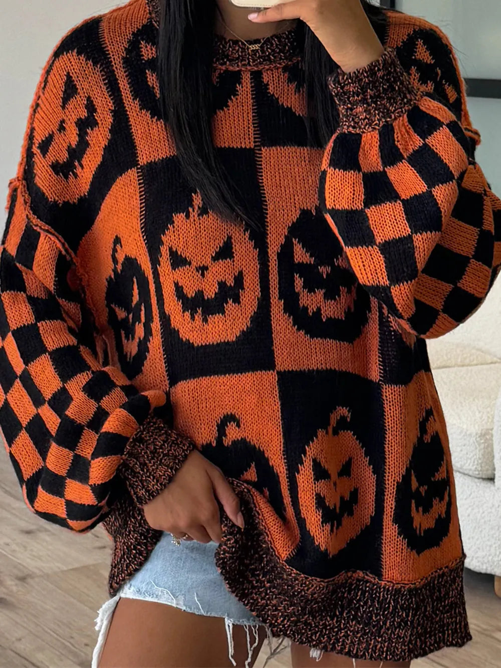 Orange and black pumpkin and checkerboard print long-sleeve sweater.