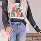 A woman wears a black long-sleeve t-shirt with a "Give Thanks" pumpkin graphic.