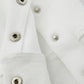 Close-up of a white hoodie with silver snap buttons and ribbed cuffs.