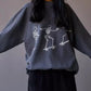 Oversized gray sweatshirt with white skeleton graphic and black corduroy shorts.