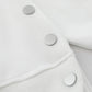 Close-up of a white hoodie with three silver side buttons.