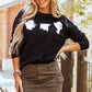 A woman wears a black long-sleeve sweatshirt with three white ghost graphics.