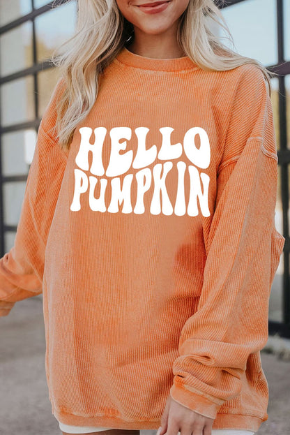 A woman wears an orange "HELLO PUMPKIN" graphic sweatshirt.