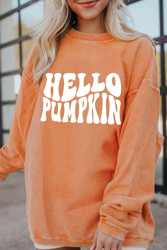A woman wears an orange "HELLO PUMPKIN" graphic sweatshirt.