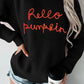 Black "Hello Pumpkin" round neck long sleeve sweater with distressed denim shorts.