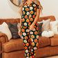 A woman models a pumpkin-printed short-sleeve top and pants lounge set.