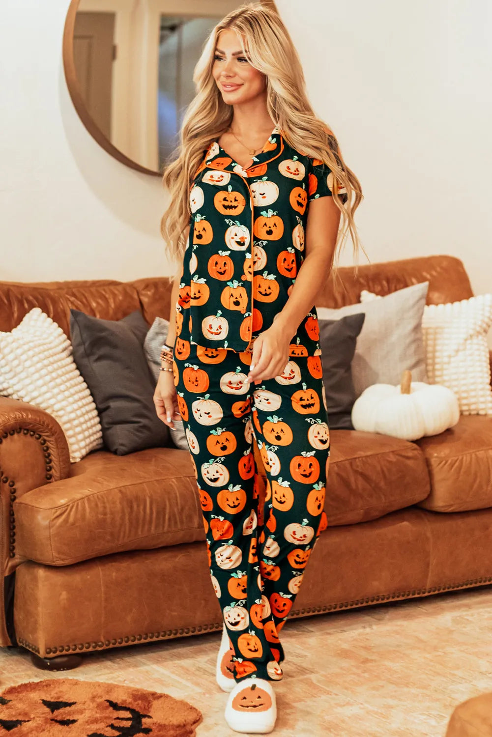 A woman models a pumpkin-printed short-sleeve top and pants lounge set.